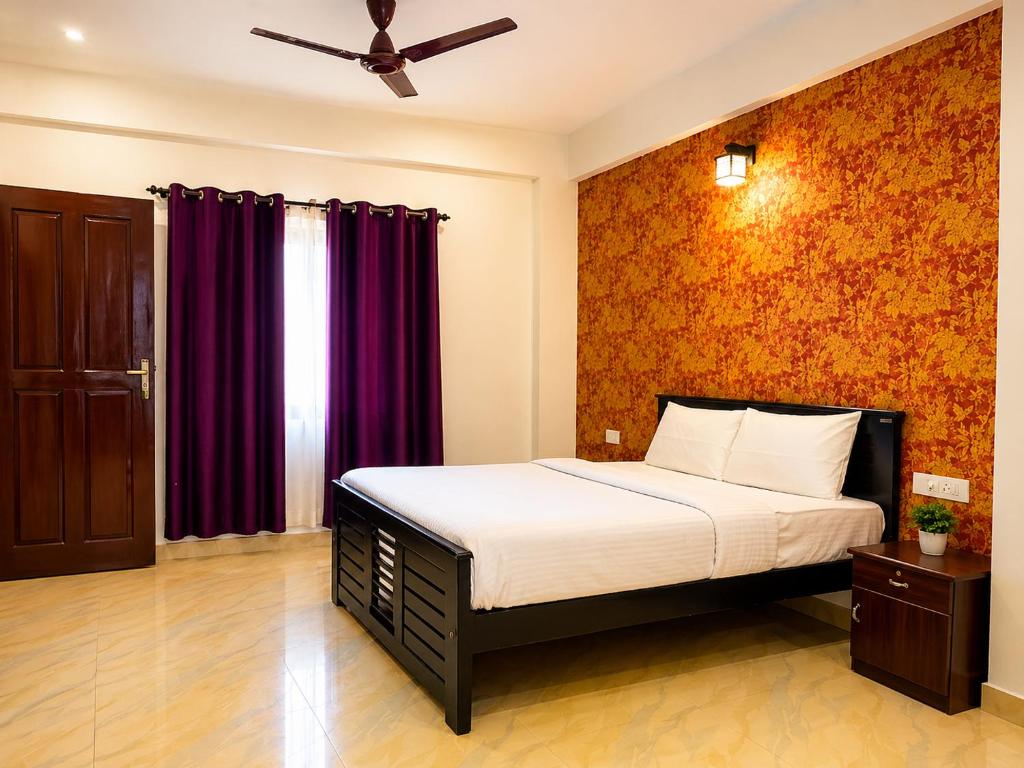a bedroom with a bed and purple curtains at Courtyard Residency Thekkady in Thekkady