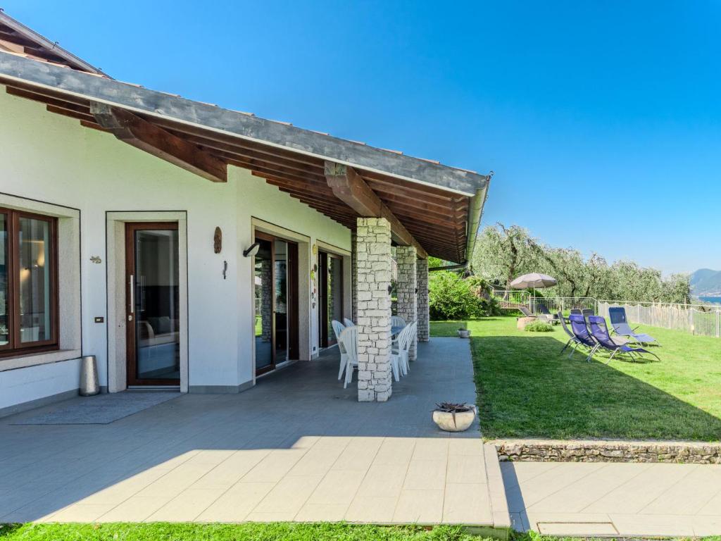 a house with a patio with chairs and an awning at Villa Manuela by Interhome in Brenzone sul Garda