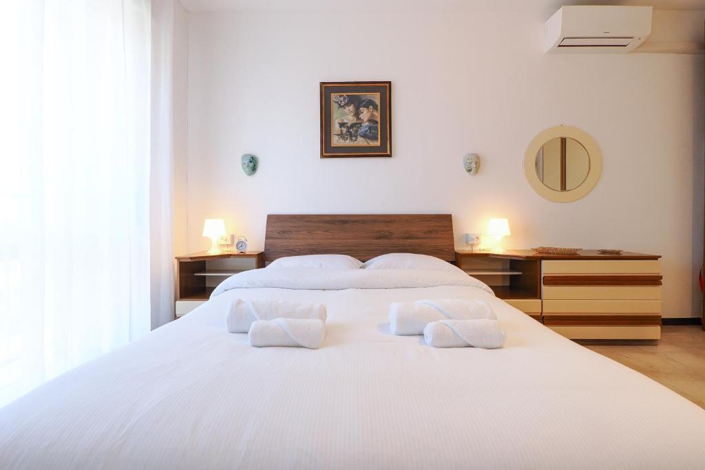 a white bedroom with a large white bed with two pillows at PrimoPiano - Padova 256 in Milan