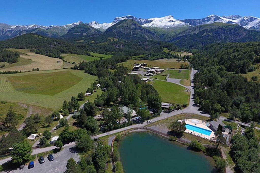 an aerial view of a resort with a lake and mountains at Camping Lou Passavous in Le Vernet