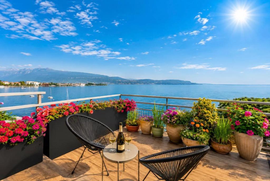 a balcony with flowers and a table and chairs at Open Space Mi Alma Lake View in Toscolano Maderno
