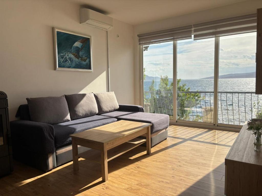 a living room with a couch and a large window at Apartman Helena in Senj