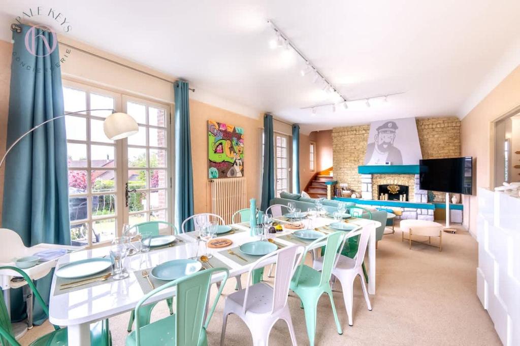 a dining room with tables and chairs and a fireplace at L'Escale - Maison 5CH & Jardin in Bray-Dunes