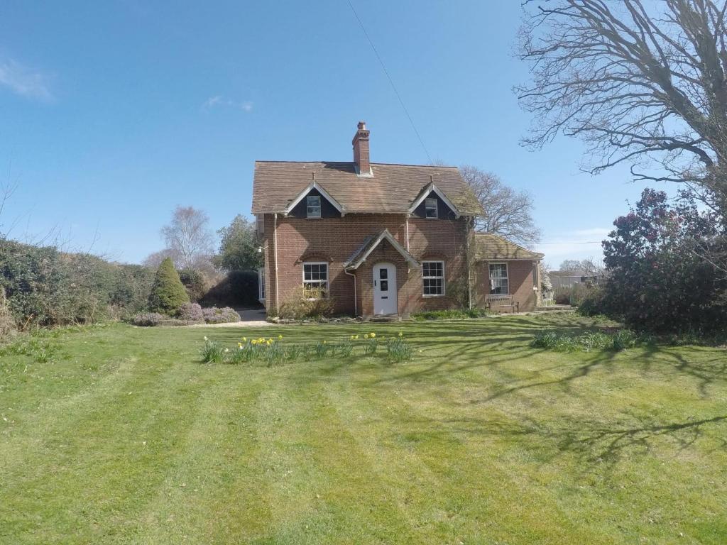 an old brick house with a grass yard at Pinecroft B&B in Lymington