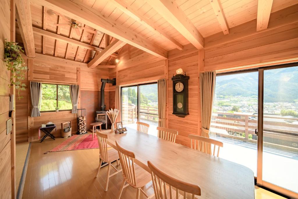 a dining room with a large wooden table and chairs at 結の里 in Gero