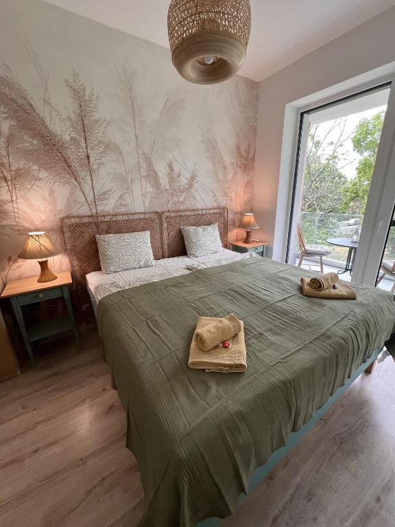 a bedroom with a bed with two towels on it at Olive II Apartman in Alsóörs