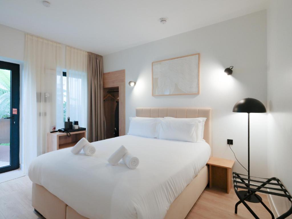 a bedroom with a large white bed with white pillows at City Pop 2Night Paris - Self check-in in Vanves
