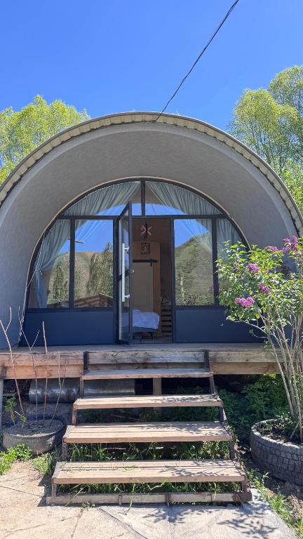 a round house with stairs leading to the entrance at Swallow in Karakol