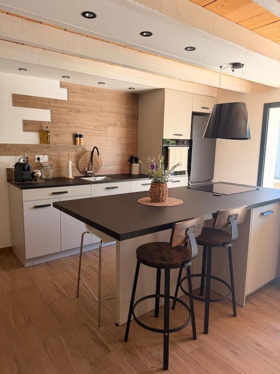 a kitchen with a large island with two bar stools at L apparte Sciez in Sciez