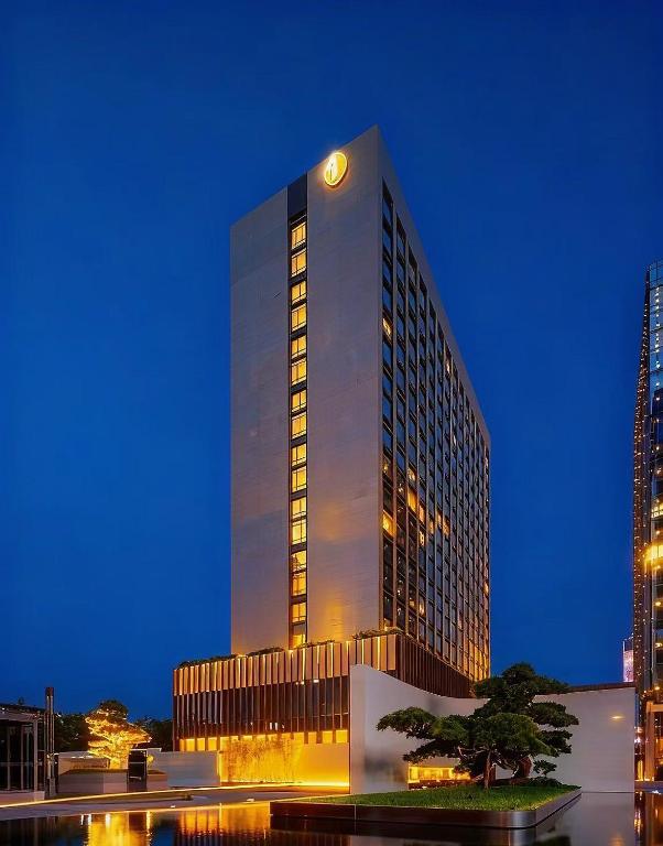 a tall building with a clock on top of it at BangTai International Aparthotel-3min walk to Line 8 Modiesha Subway STN-20min to Pazhou Exhibition Center in Guangzhou
