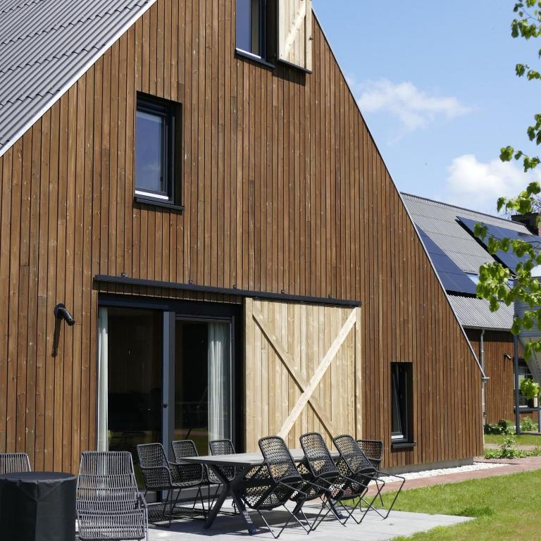 a group of chairs around a table in front of a building at Lennepserf - T Farrel in Veessen