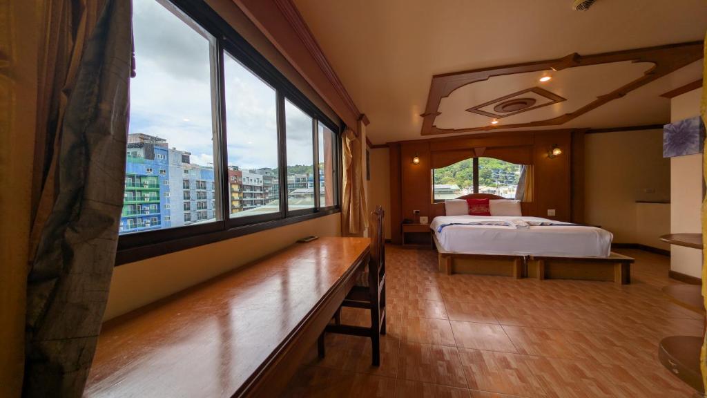 a bedroom with a bed and a large window at Tiger Complex Hotel and Restaurant in Patong Beach