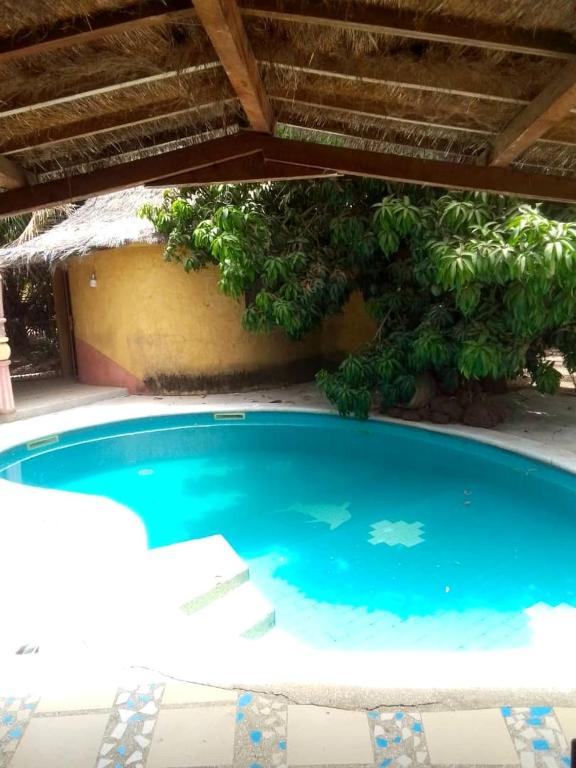 a swimming pool in front of a house at Ecolodge EcoFarm Fimela in Fimela