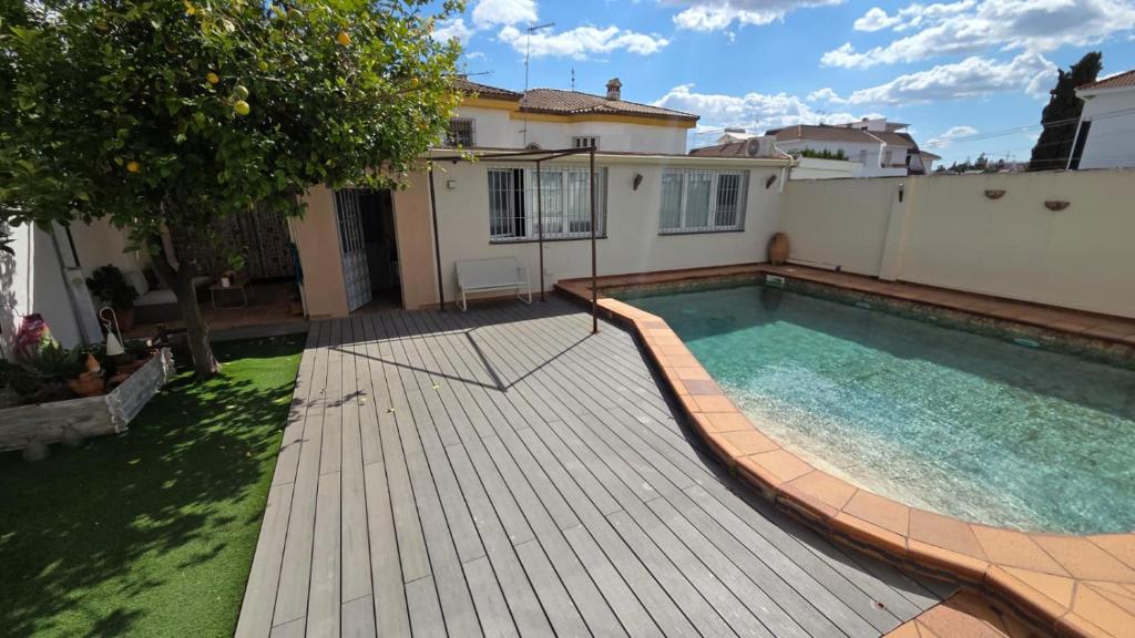 ein Garten mit Swimmingpool und ein Haus in der Unterkunft Poly's House in Tomares