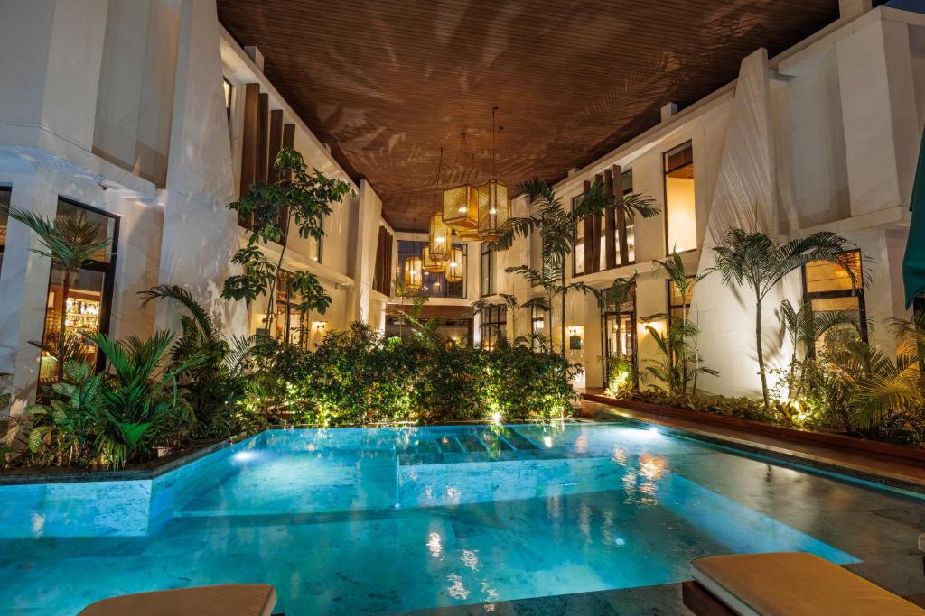 a swimming pool in the middle of a building at La Maison Palmier Abidjan, a Member of Design Hotels in Abidjan