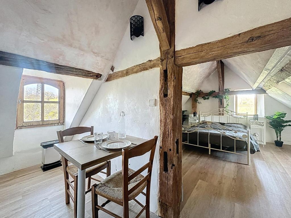 a dining room with a table and a bed in a room at Charming studio Terrace and parking in Le Mans