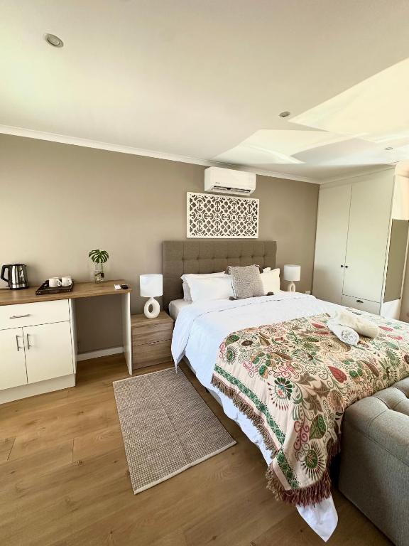 a bedroom with a large bed and a couch at Wellway Place in Durbanville