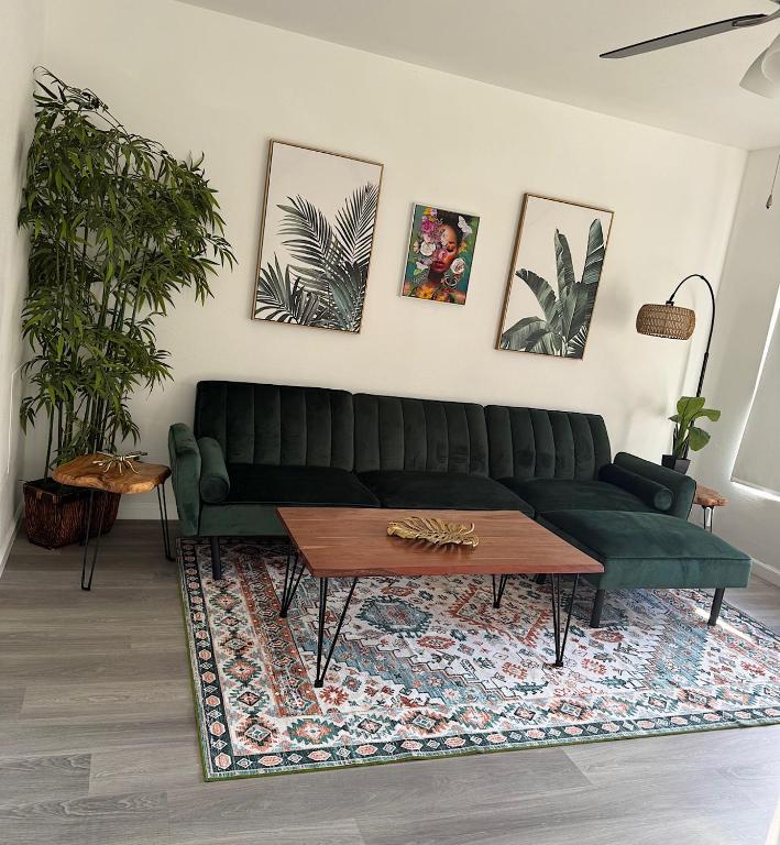 a living room with a green couch and a table at Renovated Condo Lake Eola View Great Location in Orlando