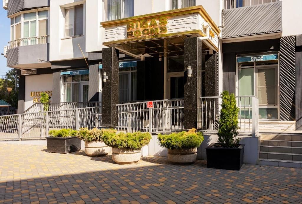 a building with potted plants in front of a store at Ribas Rooms Odesa in Odesa