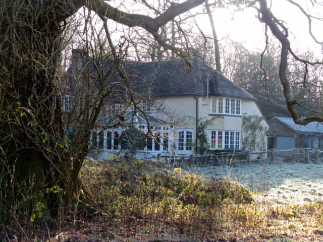 een groot wit huis met een zwart dak bij Bridge Cottage in Midhurst