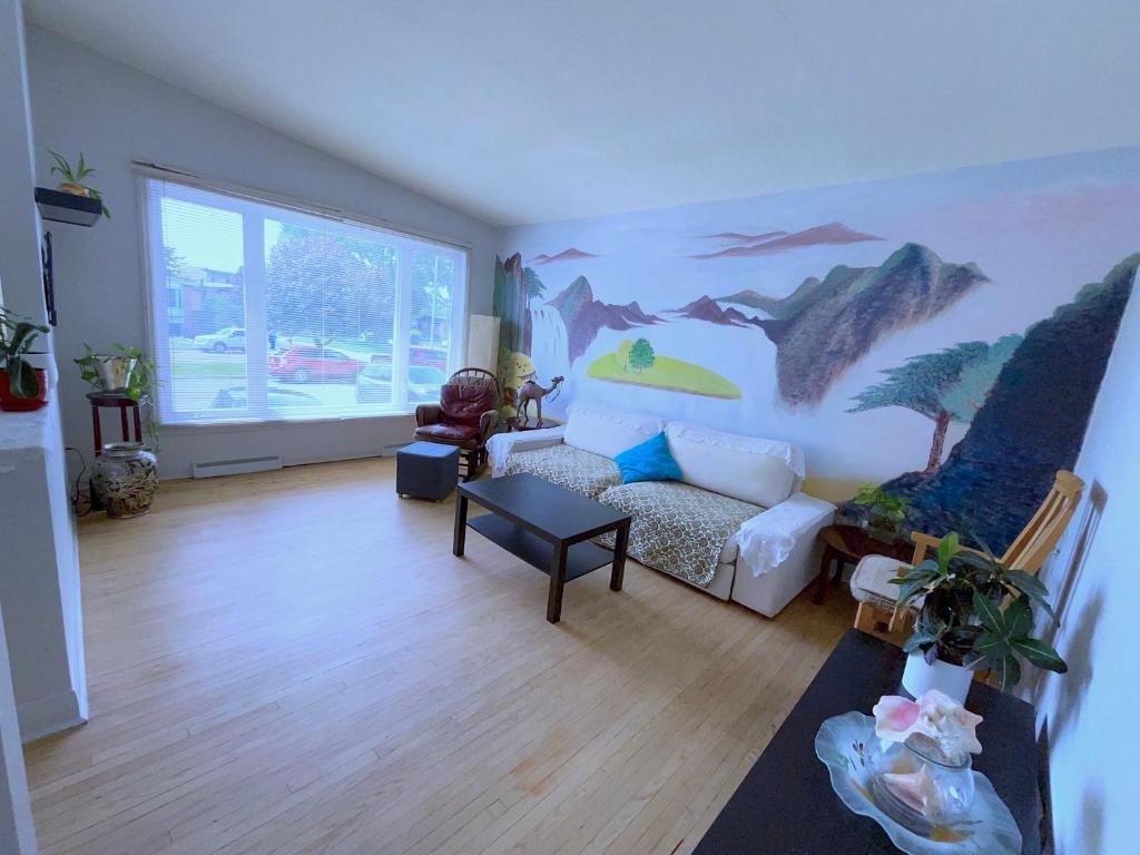 a living room with a painting on the wall at Bright Private Room near Montreal Fast WiFi in Brossard