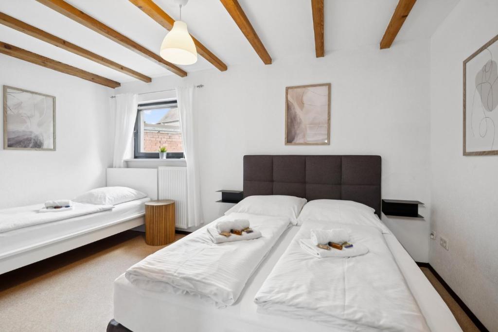 a bedroom with a large bed with white sheets at ANDRISS - Travel & Work - 5 BR - Kitchen - Parking in Kaiserslautern