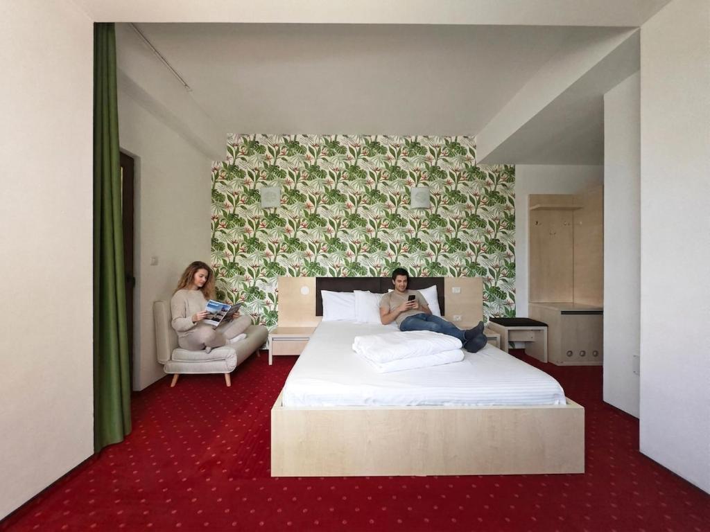 two women sitting on a bed in a bedroom at Alma by iVAVev Is'us in Mamaia