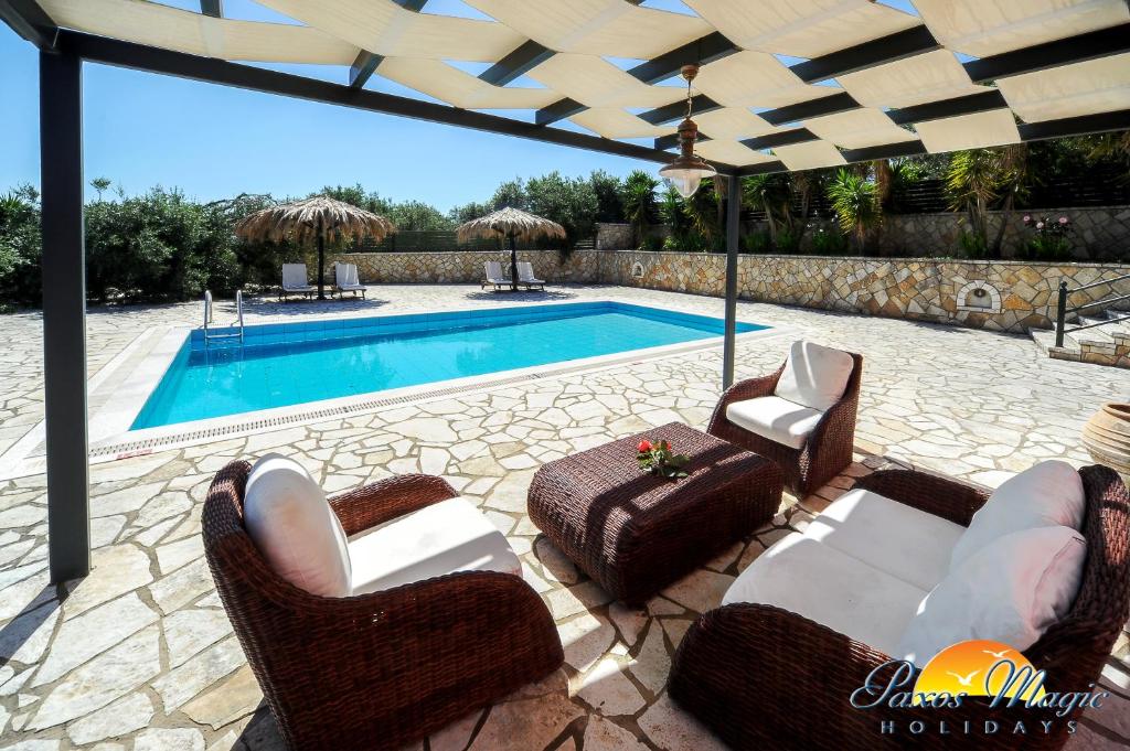 a patio with chairs and a swimming pool at Blue Horizon in Gaios