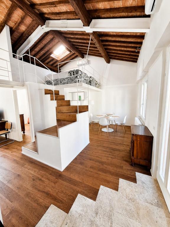 a room with a staircase and a table and chairs at il "Terrazzino" nel cuore di Siena in Siena