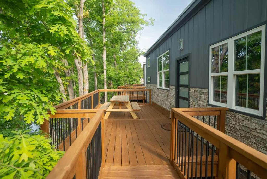 a wooden deck with a picnic table on a house at Greystone - Cozy 2-bedroom Tiny Home in soothing Anderson SC on Lake Hartwell in Anderson