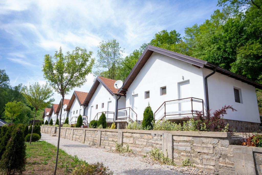 a row of white houses with a stone fence at Vuk Etno domaćinstvo in Barajevo
