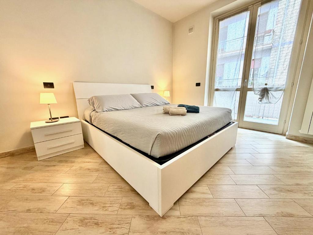 a bedroom with a large bed and a large window at Dimora del Centro in Acqui Terme