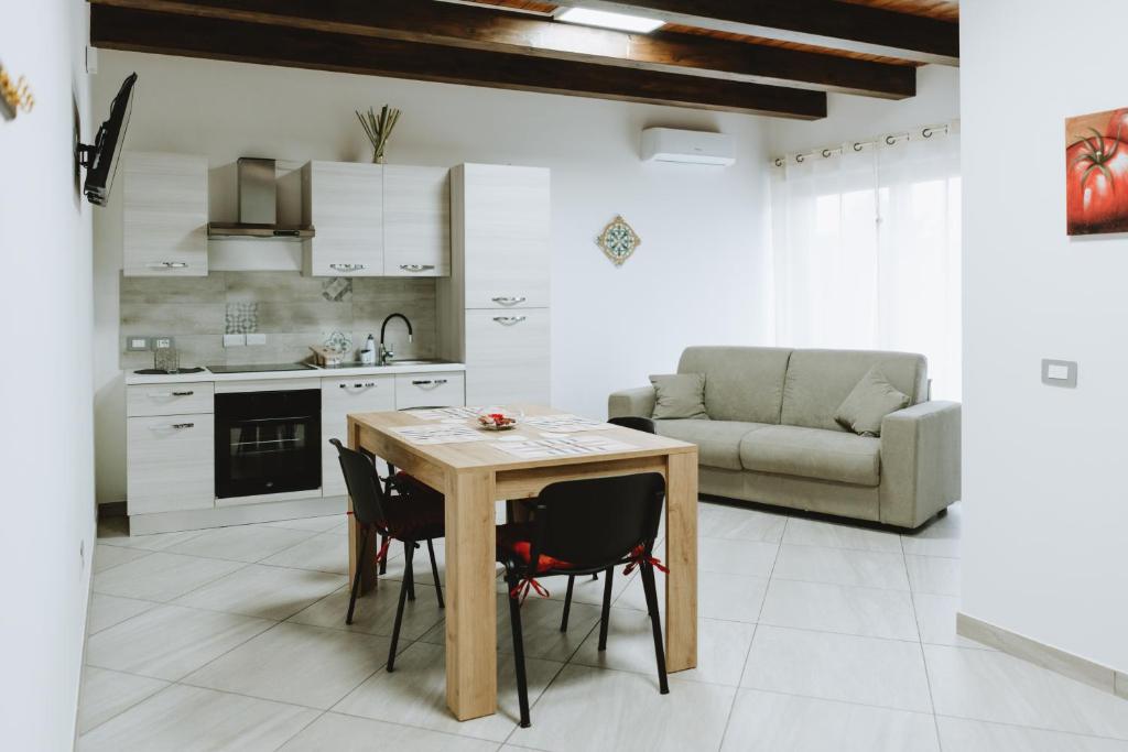 a kitchen and living room with a table and chairs at Aura Residence in San Biagio