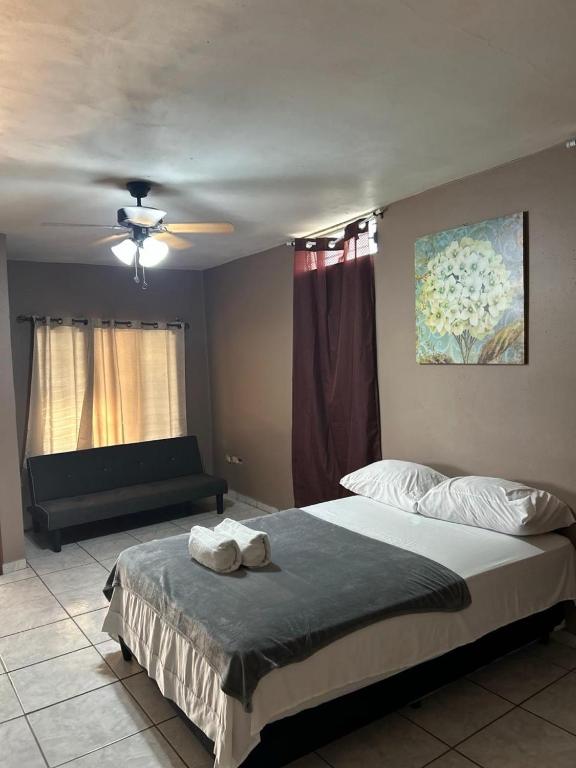 a bedroom with a large bed and a couch at Espacio Hermes Tu Rincón Céntrico in Comayagua