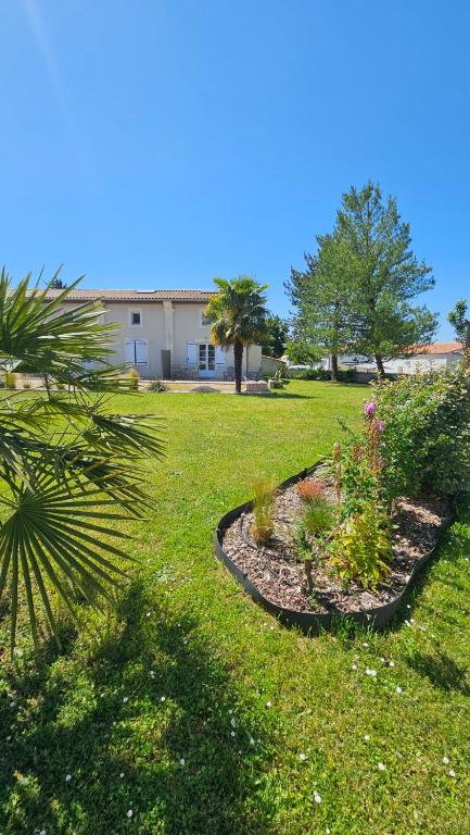 a yard with some plants in the grass at GITE familiale avec piscine in Saint-Martin-de-la-Coudre