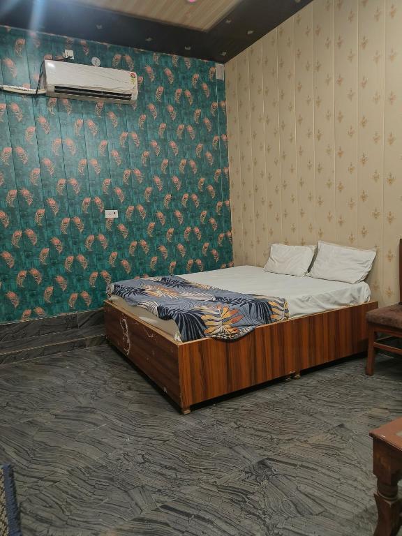 a bed in a room with a wall with flowers at Rao sahab hotel and restaurant in Etah