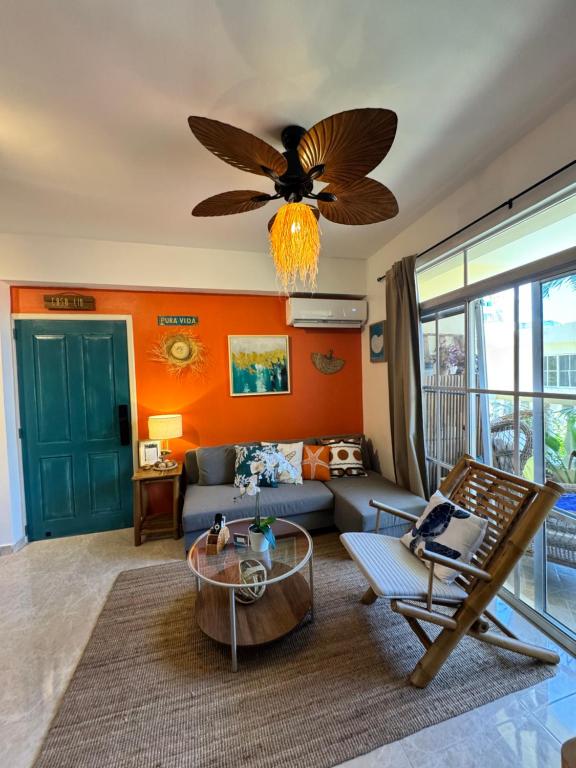 a living room with a couch and a ceiling fan at Casa Lio, Caribbean Pool Residence in Boca Chica