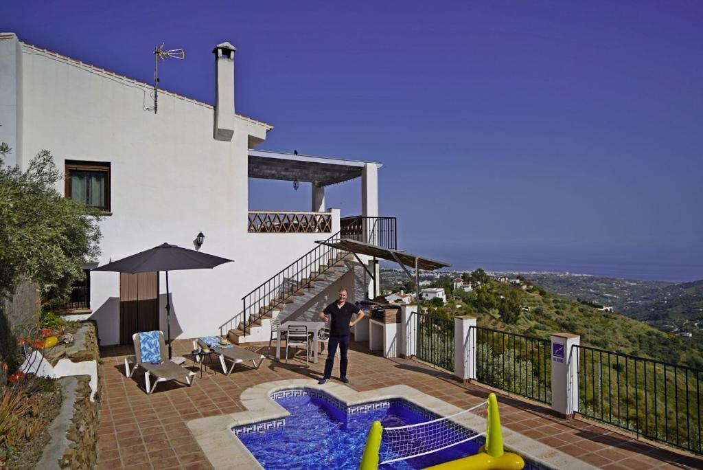 a man standing on the balcony of a house at Villa El Regalo in Frigiliana