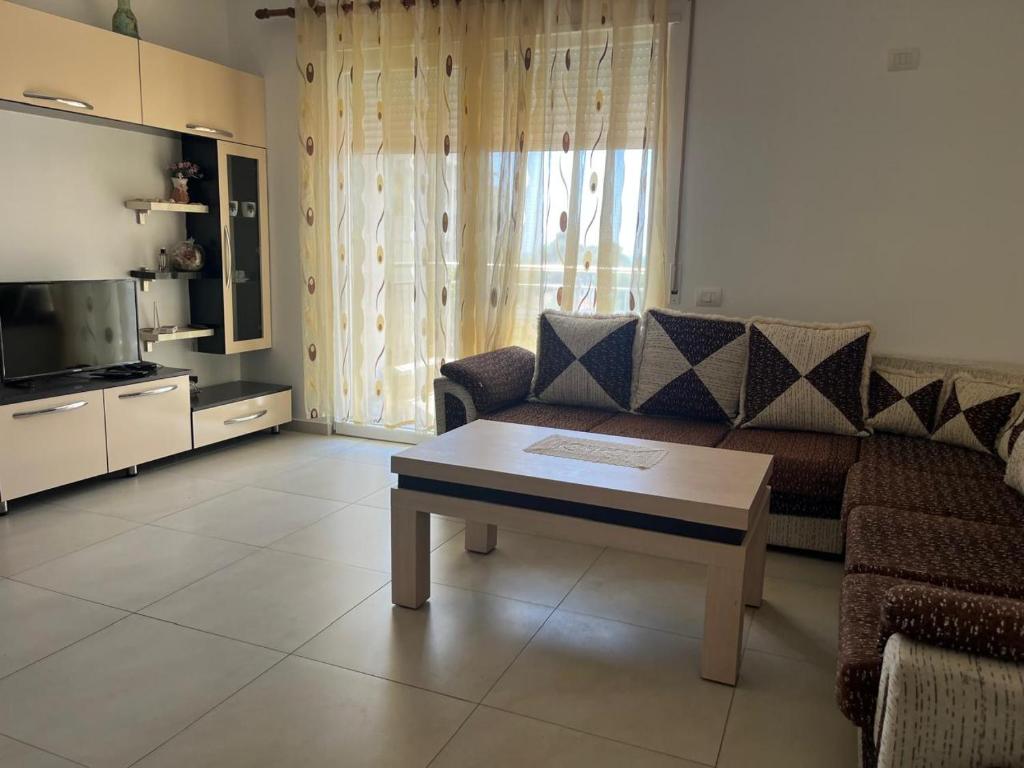 a living room with a couch and a coffee table at Katalea Apartment in Shëngjin