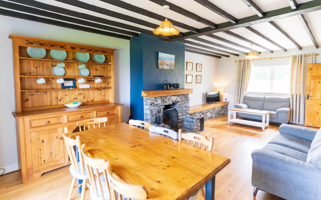 a dining room with a table and a fireplace at Perewinkle Cottage - Portmagee in Lateeve