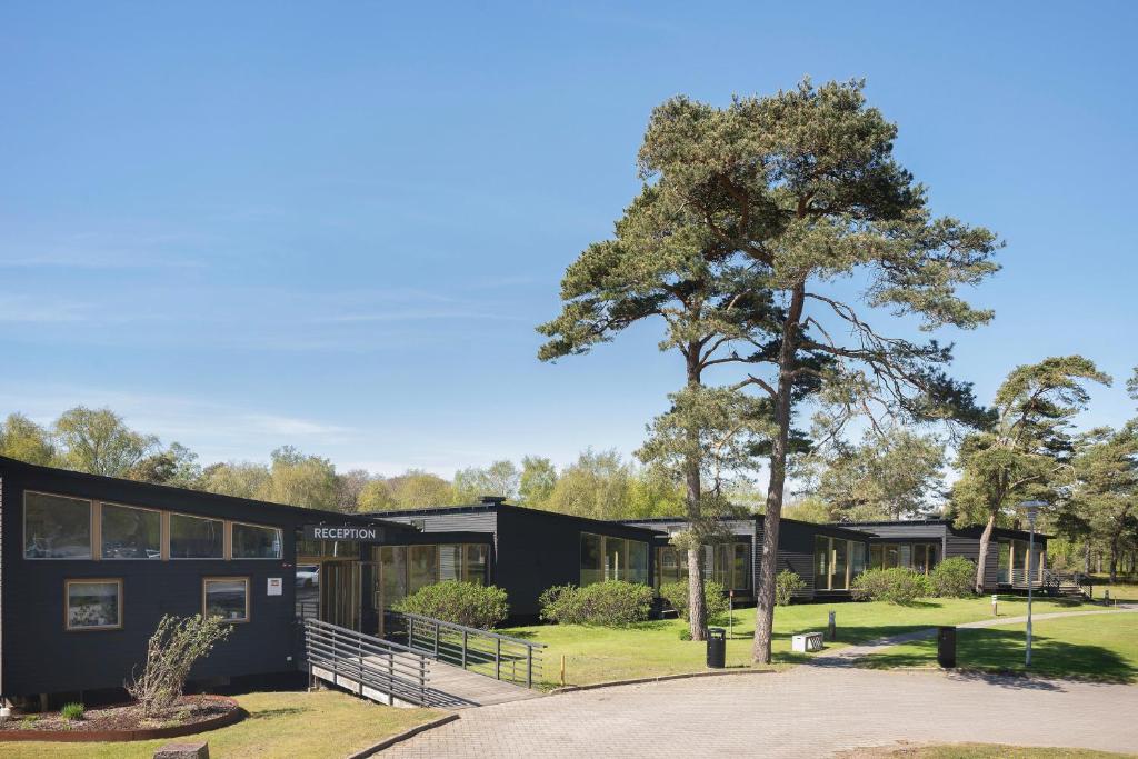 a black house with a tree in front of it at Tylebäck Hotell & Konferens, BW Signature Collection in Halmstad