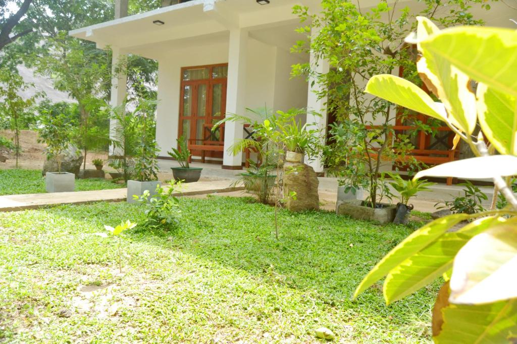 una casa con un patio con césped verde y plantas en girilena resort en Dambulla