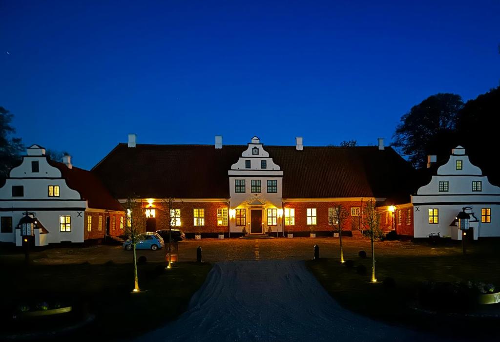 a large white house at night with lights on at Estrup Hovedgaard in Vejen