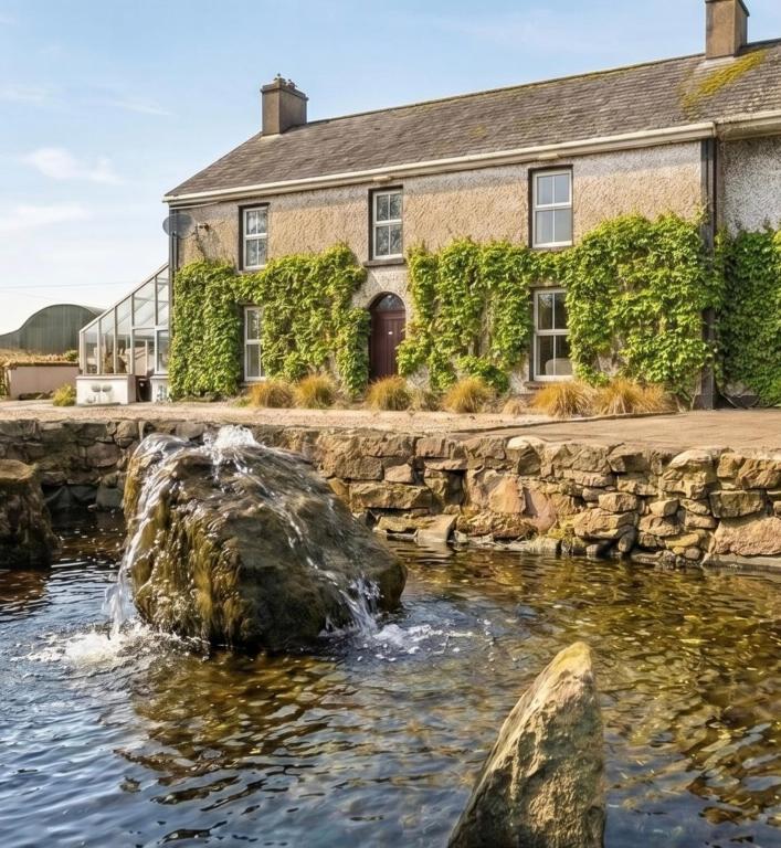 a house with a water fountain in front of it at Fitz of Inch - Entire Venue Rental in Stradbally