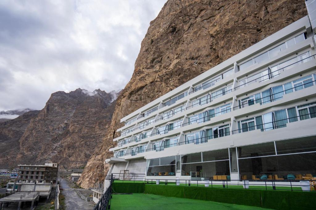 a building in front of a mountain at Pearl Continental Attabad Lake, Hunza in Hunza Valley