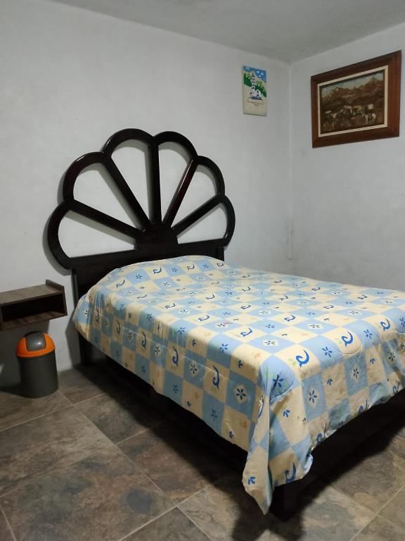 a bedroom with a bed with a blue and white comforter at Arca de Noé in Xaltepec