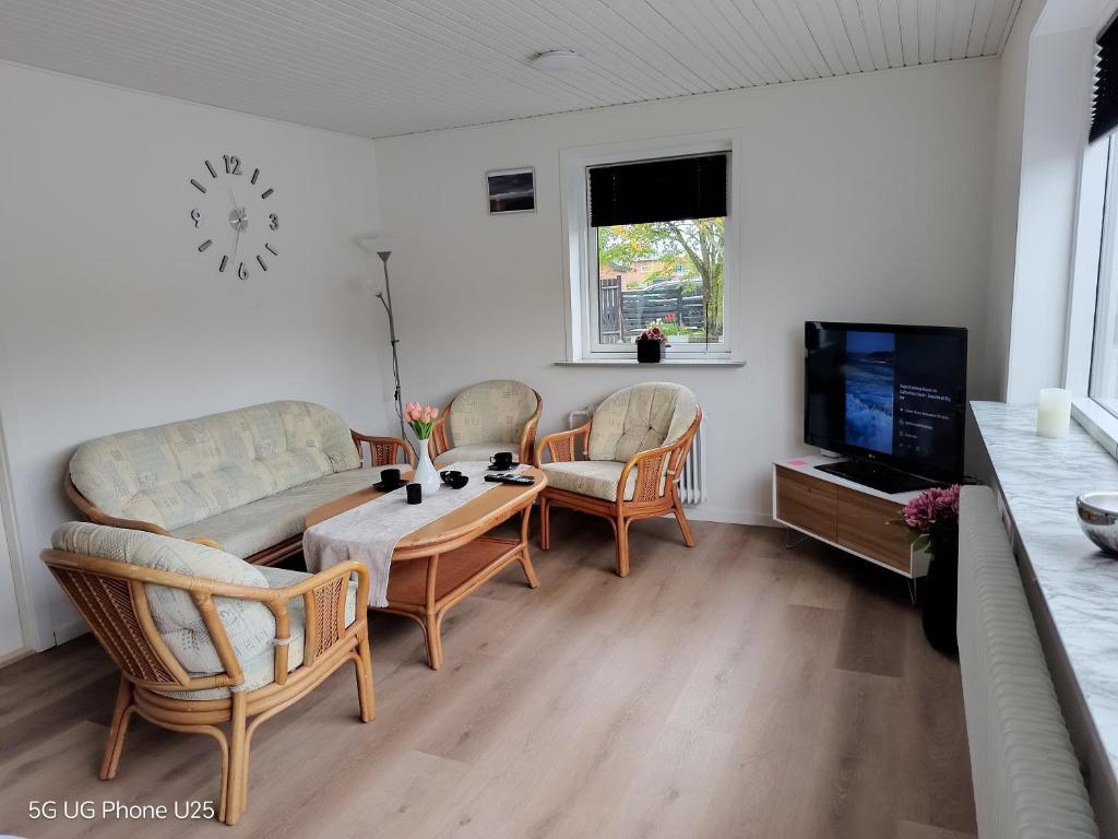 a living room with a couch and a table and a tv at Venos Home 2 in Lemvig