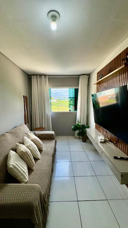 a living room with a couch and a flat screen tv at 1- Apartamento aconchegante 1200m do Centro in Serra Talhada