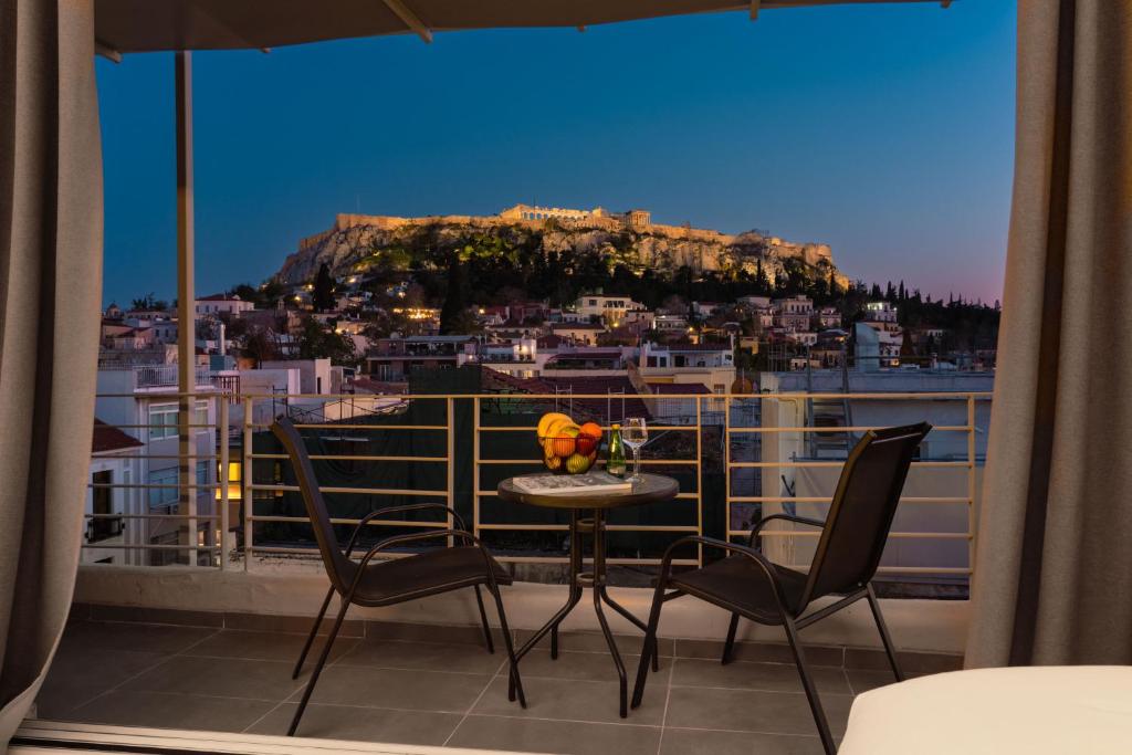 a balcony with a table and chairs and a view of a city at 24K Athena Suites in Athens