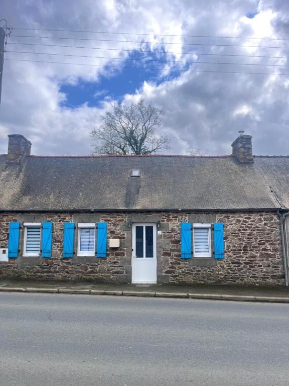 a brick house with blue shutters on the windows at Gîte de L'embarcadère in Moustéru